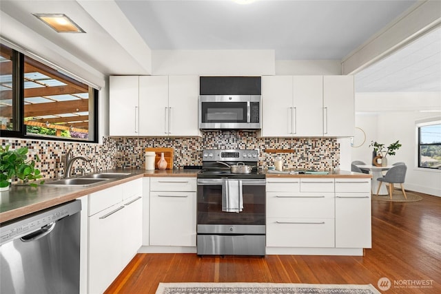 4742 22nd Ave SW, Seattle, WA 98106 - kitchen featuring appliances with stainless steel finishes, a sink, dark wood-style floors, and backsplash