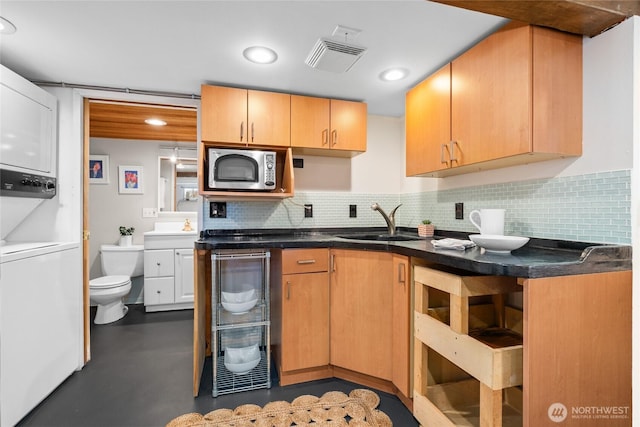 4742 22nd Ave SW, Seattle, WA 98106 - kitchen featuring stainless steel microwave, estacked washer and dryer, a sink, backsplash, and recessed lighting
