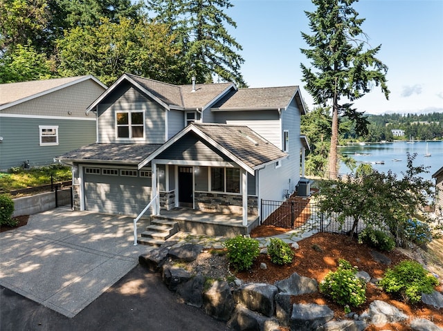 931 Oyster Bay Ct, Bremerton, WA 98312 - view of front facade featuring covered porch, a garage, concrete driveway, a water view, and roof with shingles