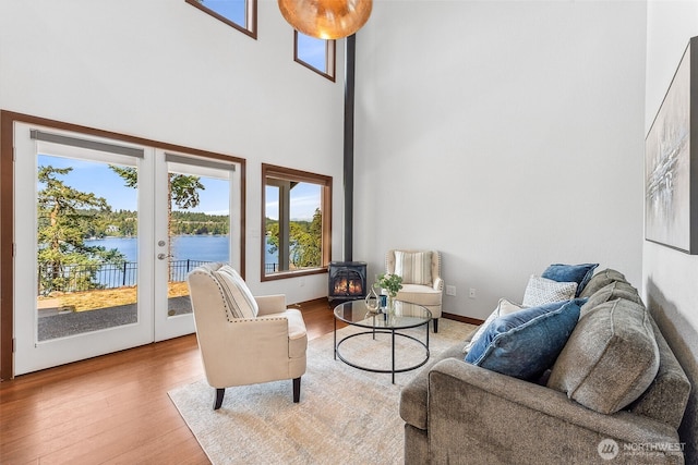 931 Oyster Bay Ct, Bremerton, WA 98312 - living room with a wood stove, a high ceiling, french doors, healthy amount of natural light, and light wood-style floors