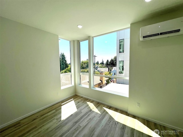 8324 16th Ave NW Unit A, Seattle, WA 98117 - empty room featuring an AC wall unit, wood finished floors, recessed lighting, and baseboards