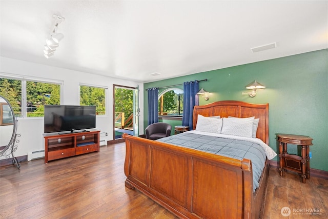 961 W Lake Samish Dr, Bellingham, WA 98229 - bedroom with a baseboard radiator, wood finished floors, access to exterior, and track lighting