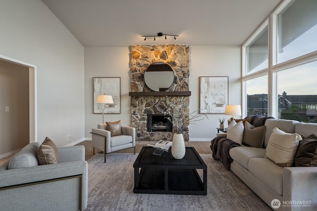 5110 NW Sammamish Rd, Issaquah, WA 98027 - living area with track lighting, baseboards, wood finished floors, and a stone fireplace