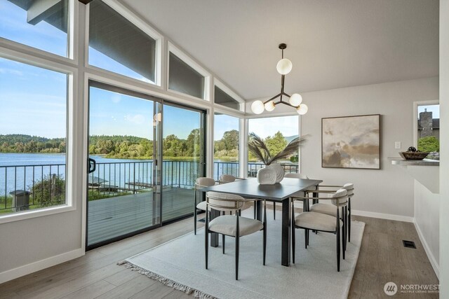 5110 NW Sammamish Rd, Issaquah, WA 98027 - dining area with a water view, vaulted ceiling, a chandelier, baseboards, and wood finished floors