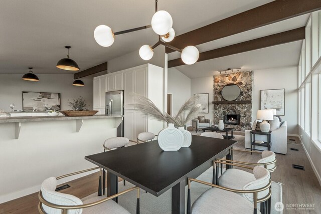 5110 NW Sammamish Rd, Issaquah, WA 98027 - dining room featuring light wood-type flooring, a stone fireplace, baseboards, and beam ceiling