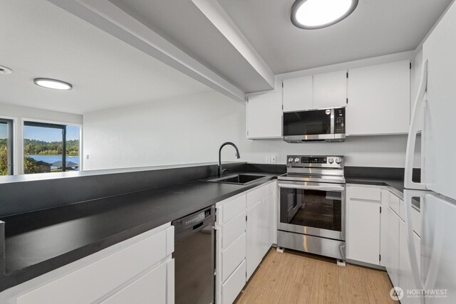 5110 NW Sammamish Rd, Issaquah, WA 98027 - kitchen with appliances with stainless steel finishes, a sink, dark countertops, white cabinets, and light wood-style floors