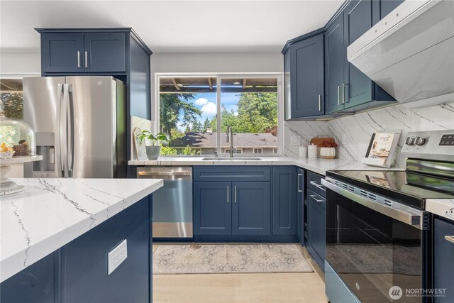 4426 NE 17th St, Renton, WA 98059 - kitchen featuring stainless steel appliances, ventilation hood, a sink, blue cabinetry, and tasteful backsplash