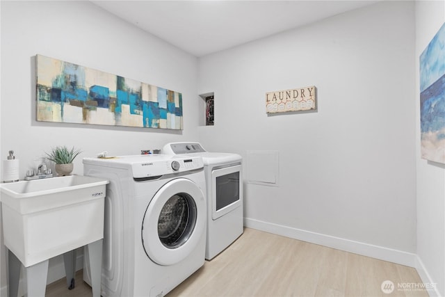 4426 NE 17th St, Renton, WA 98059 - laundry room featuring independent washer and dryer, light wood-style floors, and baseboards
