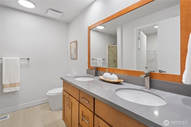4426 NE 17th St, Renton, WA 98059 - full bathroom featuring a stall shower, double vanity, toilet, a walk in closet, and baseboards