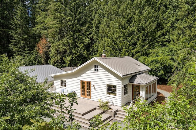 5396 Langley Rd, Langley, WA 98260 - view of front of house featuring a wooden deck, a forest view, metal roof, and a chimney