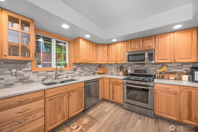 649 Summit Pl, Sedro Woolley, WA 98284 - kitchen with appliances with stainless steel finishes, a sink, light wood-style flooring, tasteful backsplash, and glass insert cabinets