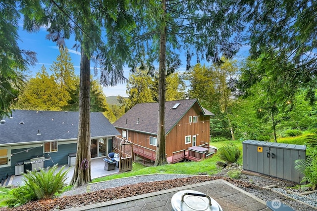 649 Summit Pl, Sedro Woolley, WA 98284 - rear view of property featuring a wooden deck, a patio area, and a fire pit