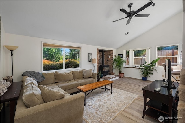 2711 Grampin Ct SE, Olympia, WA 98501 - living room featuring a wood stove, healthy amount of natural light, light wood-type flooring, a ceiling fan, and high vaulted ceiling