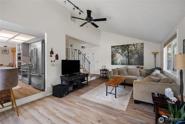 2711 Grampin Ct SE, Olympia, WA 98501 - living room featuring light wood-style floors, stairway, a ceiling fan, high vaulted ceiling, and track lighting