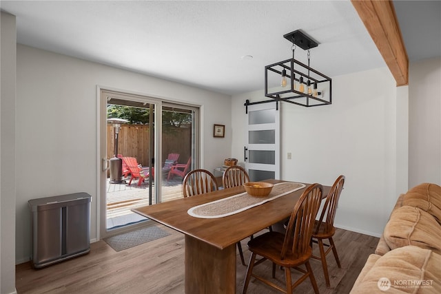 2711 Grampin Ct SE, Olympia, WA 98501 - dining space with a barn door, wood finished floors, and baseboards