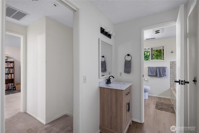 2711 Grampin Ct SE, Olympia, WA 98501 - bathroom featuring toilet, vanity, baseboards, a bath, and wood finished floors