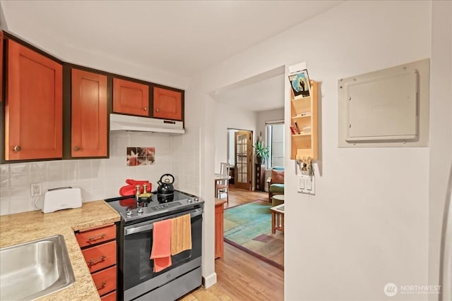 2700 4th Ave Unit 403, Seattle, WA 98121 - kitchen with stainless steel electric range oven, under cabinet range hood, light countertops, a sink, and decorative backsplash