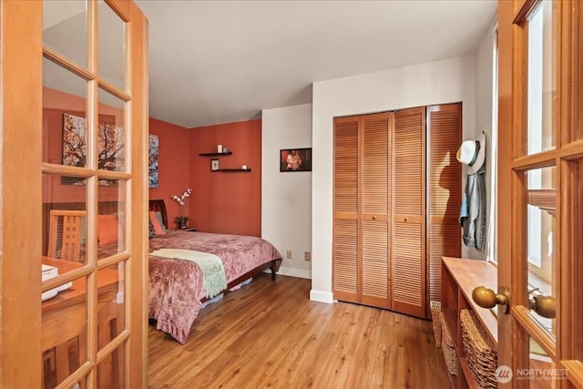 2700 4th Ave Unit 403, Seattle, WA 98121 - bedroom with light wood-style floors, a closet, baseboards, and french doors