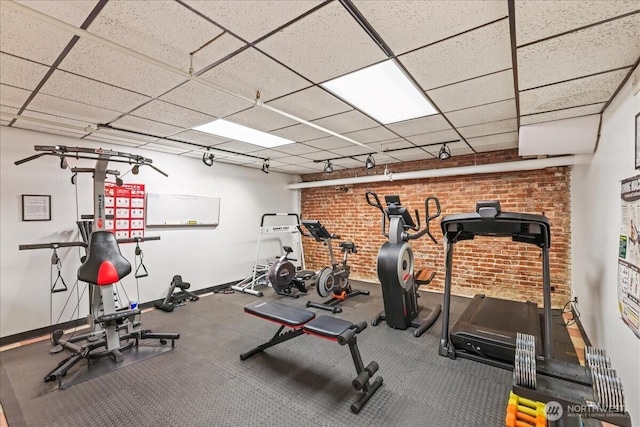 2700 4th Ave Unit 403, Seattle, WA 98121 - workout area featuring brick wall, baseboards, and a drop ceiling