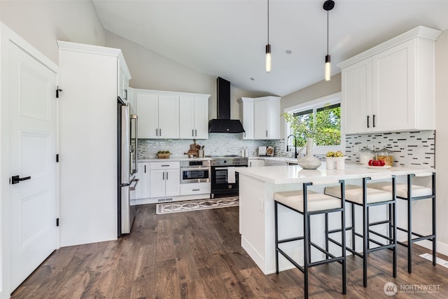 36720 55th Ave S, Auburn, WA 98001 - kitchen with wall chimney exhaust hood, stainless steel appliances, a peninsula, lofted ceiling, and a kitchen breakfast bar