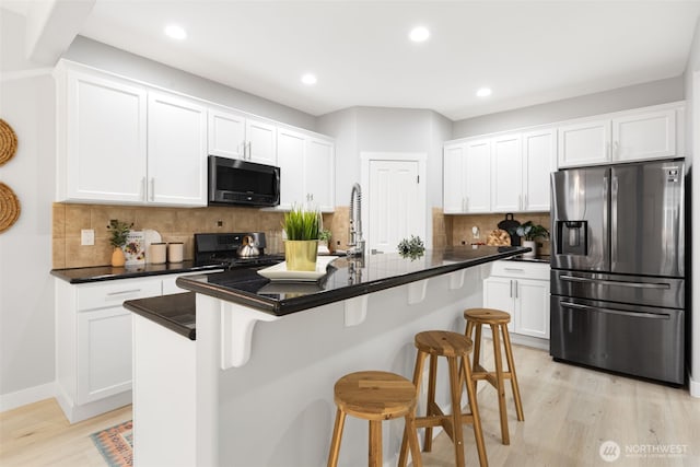 17826 20th Ave SE, Bothell, WA 98012 - kitchen with appliances with stainless steel finishes, light wood finished floors, white cabinets, dark countertops, and recessed lighting