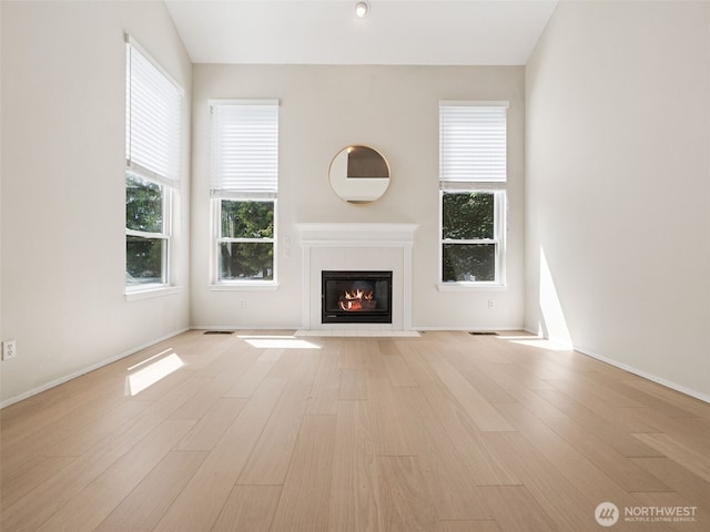 23501 112th Ave SE Unit M104, Kent, WA 98031 - unfurnished living room featuring a tile fireplace, light wood finished floors, and baseboards