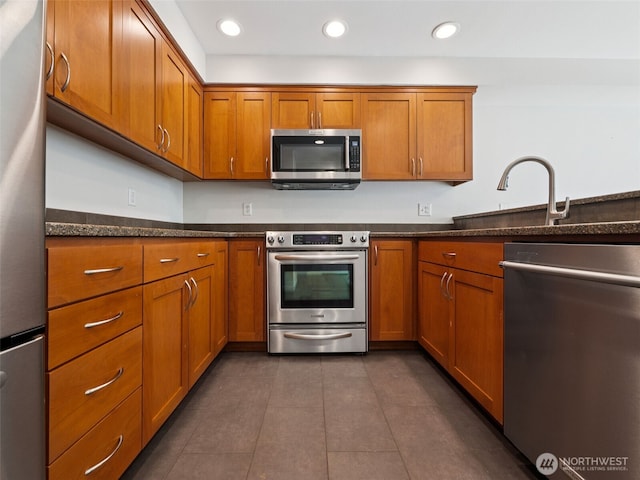 23501 112th Ave SE Unit M104, Kent, WA 98031 - kitchen with appliances with stainless steel finishes, brown cabinetry, a sink, and recessed lighting