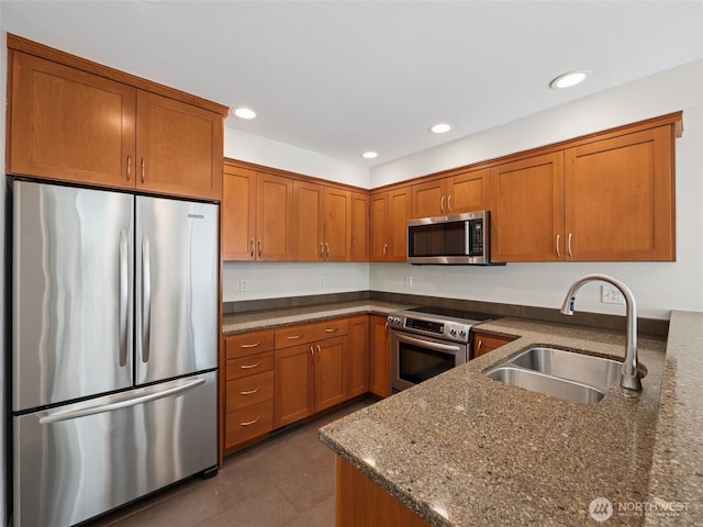 23501 112th Ave SE Unit M104, Kent, WA 98031 - kitchen with appliances with stainless steel finishes, a sink, brown cabinetry, dark stone countertops, and recessed lighting