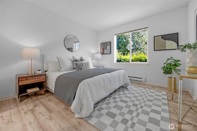 2009 196th St SE Unit G104, Bothell, WA 98012 - bedroom featuring a baseboard heating unit, light wood-style flooring, and baseboards