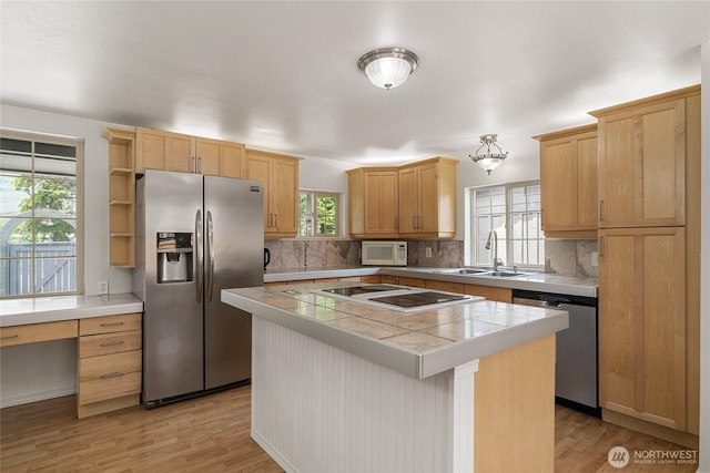330 Highland Ave, Chelan, WA 98816 - kitchen with stainless steel appliances, a sink, a kitchen island, backsplash, and light wood-style flooring