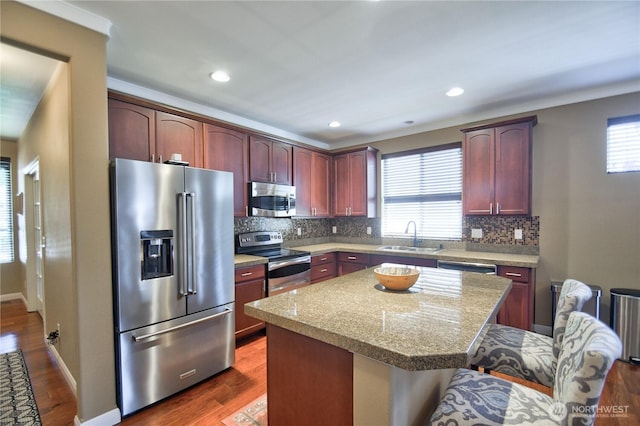 9127 Perwinkle Loop NE, Olympia, WA 98516 - kitchen with appliances with stainless steel finishes, a sink, tasteful backsplash, a center island, and ornamental molding