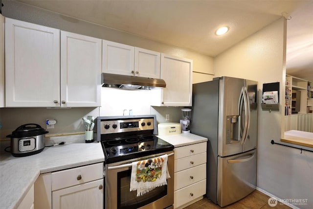 19523 71st Ave E, Spanaway, WA 98387 - kitchen featuring stainless steel appliances, under cabinet range hood, light countertops, white cabinetry, and recessed lighting