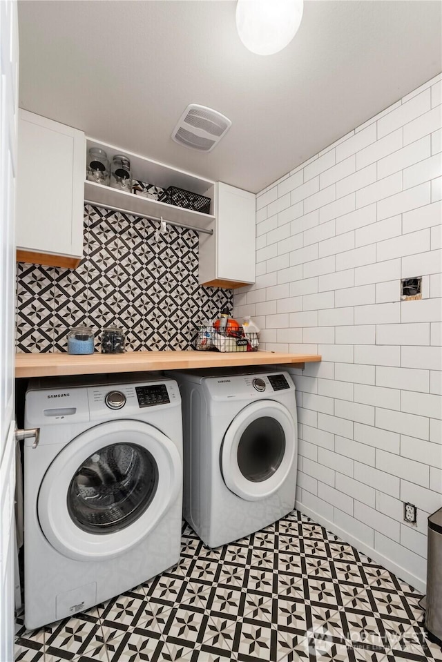 18113 17th Avenue Ct E, Spanaway, WA 98387 - washroom with washer and clothes dryer, tile patterned floors, tile walls, and cabinet space