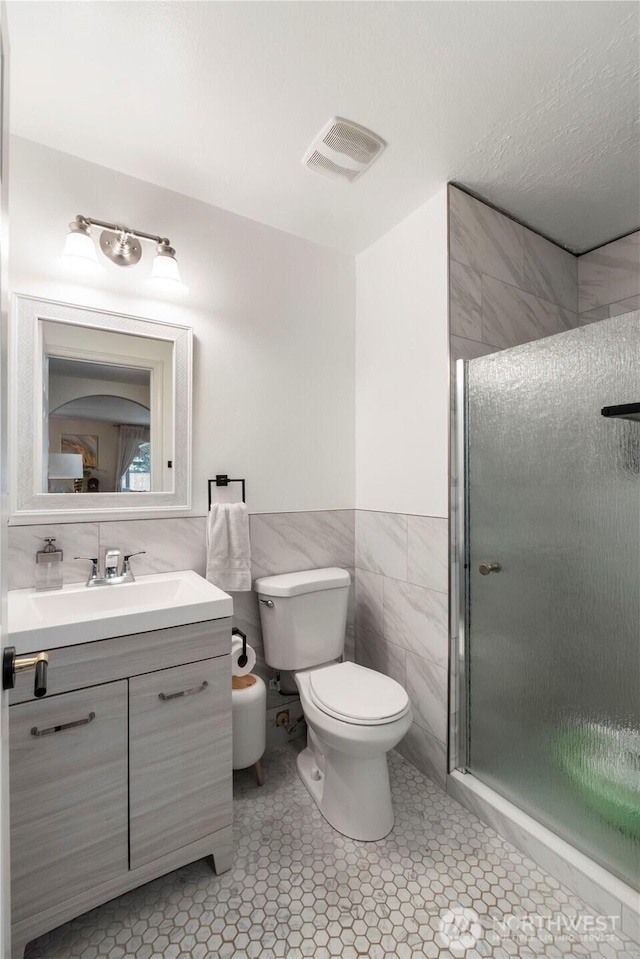 18113 17th Avenue Ct E, Spanaway, WA 98387 - full bath featuring tile walls, vanity, a stall shower, toilet, and wainscoting