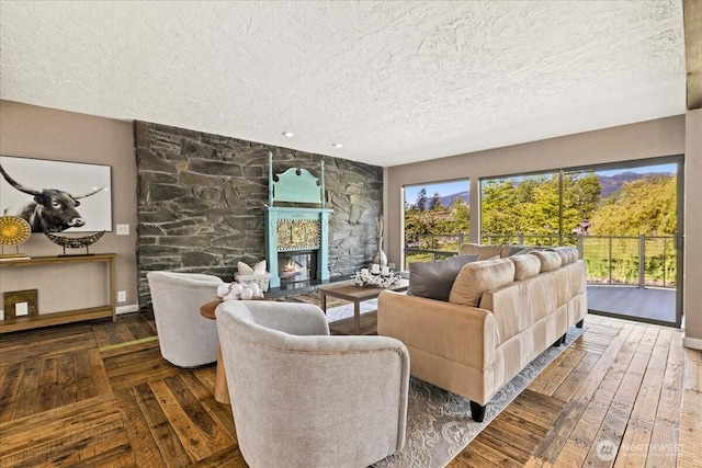 41506 292nd Way SE, Enumclaw, WA 98022 - living room featuring a textured ceiling, a stone fireplace, baseboards, and hardwood / wood-style floors