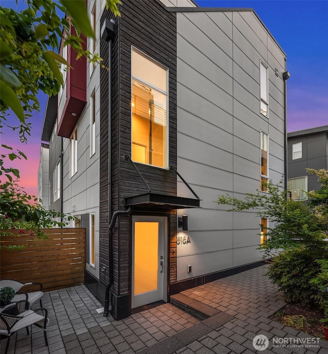 818 25th Ave S Unit A, Seattle, WA 98144 - back of house at dusk featuring a patio area