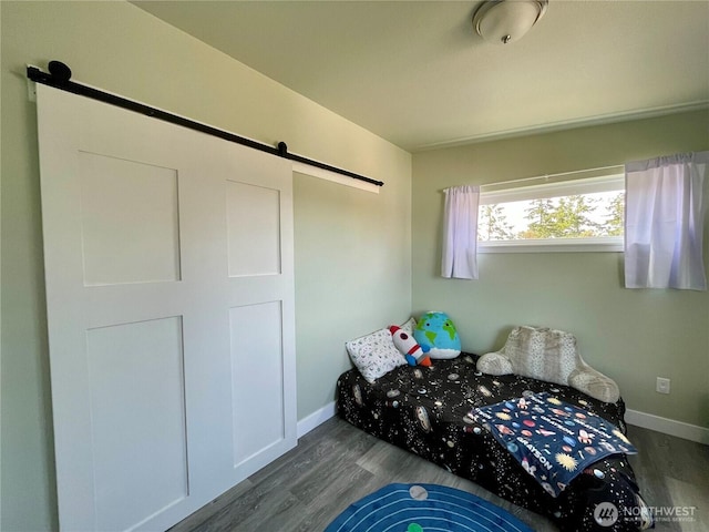 585 Finnegan Rdg, Friday Harbor, WA 98250 - bedroom featuring a barn door and dark wood-type flooring