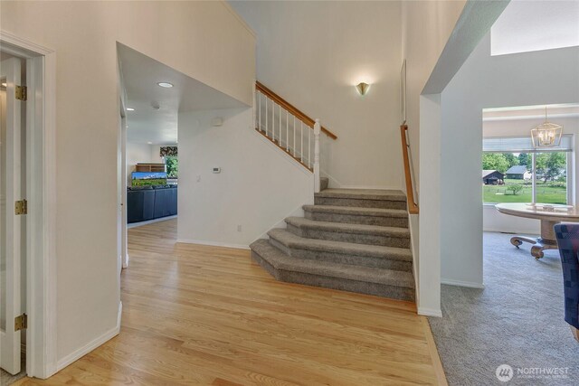 11207 16th St E, Edgewood, WA 98372 - staircase with wood finished floors, baseboards, a chandelier, and a high ceiling