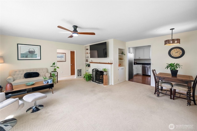 6901 Columbia Ct, Everett, WA 98203 - carpeted living room with ceiling fan, built in shelves, and a fireplace with flush hearth
