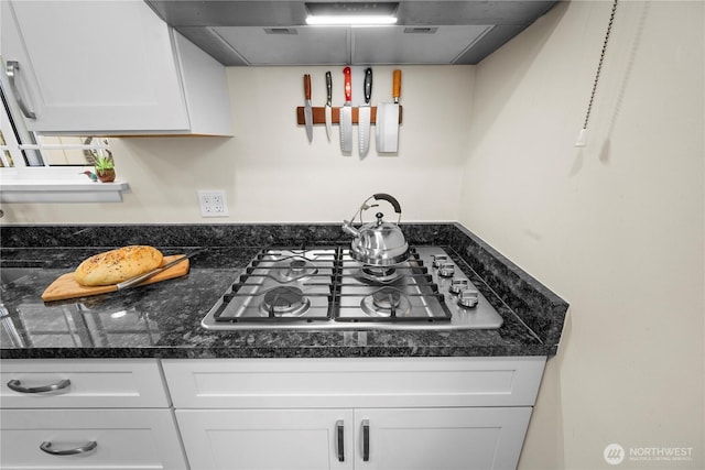 6901 Columbia Ct, Everett, WA 98203 - kitchen with stainless steel gas cooktop, white cabinetry, dark countertops, and exhaust hood