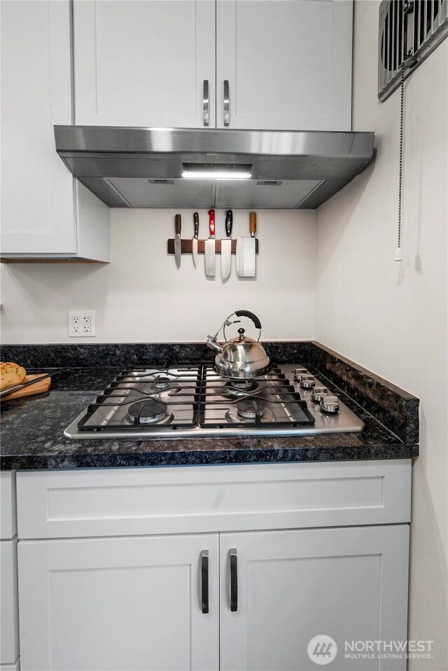 6901 Columbia Ct, Everett, WA 98203 - kitchen featuring stainless steel gas cooktop, exhaust hood, white cabinetry, and dark stone countertops