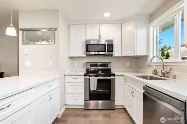 1980 Mckinley St, Enumclaw, WA 98022 - kitchen with stainless steel appliances, recessed lighting, white cabinets, light countertops, and wood finished floors
