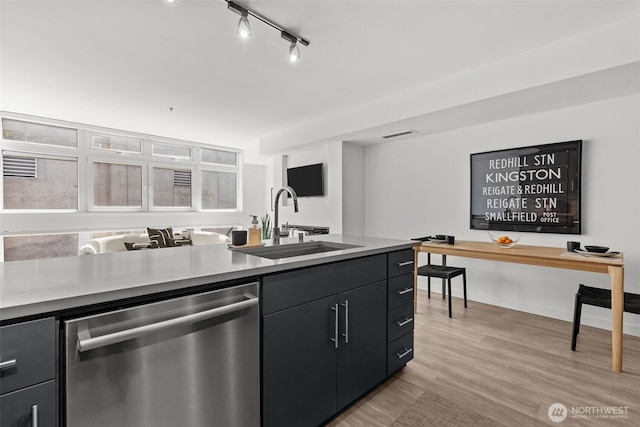 17 W Mercer St Unit 216, Seattle, WA 98119 - kitchen featuring dishwasher, a sink, light countertops, light wood-type flooring, and dark cabinetry