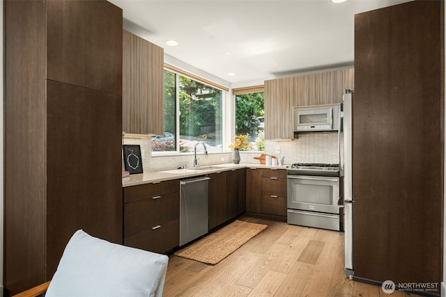 402 W Fulton St, Seattle, WA 98119 - kitchen with appliances with stainless steel finishes, light countertops, tasteful backsplash, light wood-type flooring, and recessed lighting