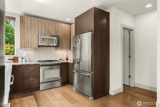 402 W Fulton St, Seattle, WA 98119 - kitchen with stainless steel appliances, light countertops, light wood-style floors, tasteful backsplash, and recessed lighting