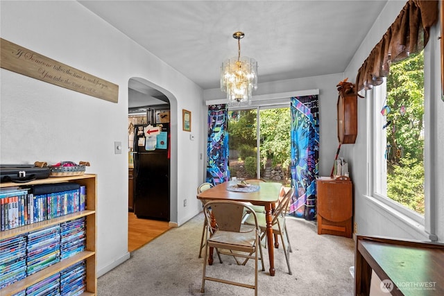354 Farallone Ave, Fircrest, WA 98466 - dining room featuring arched walkways, light colored carpet, a chandelier, and healthy amount of natural light