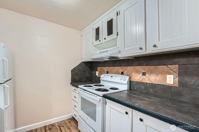 4601 SW 320th St Unit K4, Federal Way, WA 98023 - kitchen featuring white appliances, dark countertops, light wood finished floors, under cabinet range hood, and decorative backsplash