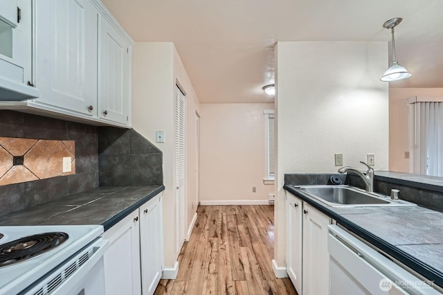 4601 SW 320th St Unit K4, Federal Way, WA 98023 - kitchen featuring white dishwasher, a sink, decorative backsplash, dark countertops, and light wood-style floors