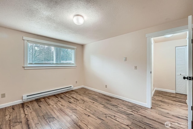 4601 SW 320th St Unit K4, Federal Way, WA 98023 - empty room with baseboard heating, wood finished floors, a textured ceiling, and baseboards