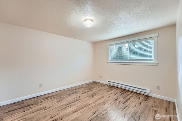 4601 SW 320th St Unit K4, Federal Way, WA 98023 - spare room featuring baseboard heating, a textured ceiling, wood finished floors, and baseboards
